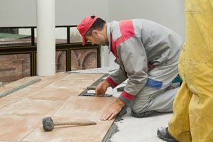 Interior rehabilitation when construction worker is installing ceramic tiles in Lemont