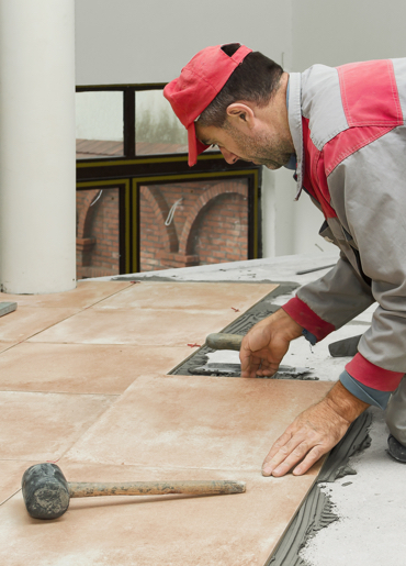 Interior rehabilitation when construction worker is installing ceramic tiles in Lemont